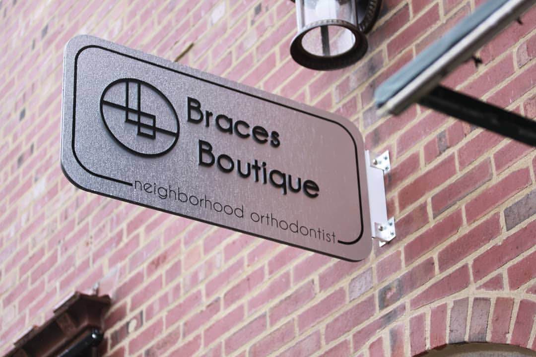 The Braces Boutique sign mounted on the brick exterior of the Oak Park office.